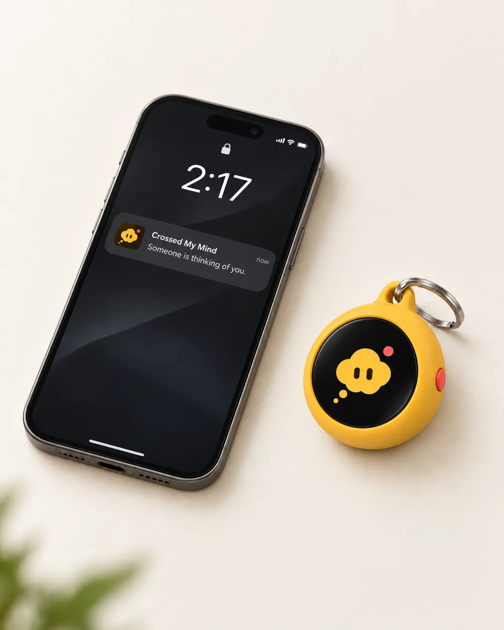 A phone lock screen at 2:17 showing a notification from Crossed My Mind: Someone is thinking of you. The keychain sits beside it.